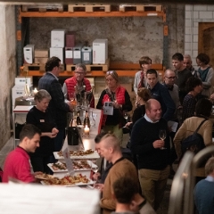 Die Besucher der Weintage im Keller am Degustieren von Cava und geniessen von spanischen Tapas